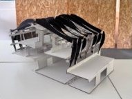 1:50 section model of Maison Peplum from the sectioned side, showing the white card floors and stair beneath black fins.